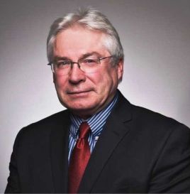 man with a black suit, blue shirt and red tie. 