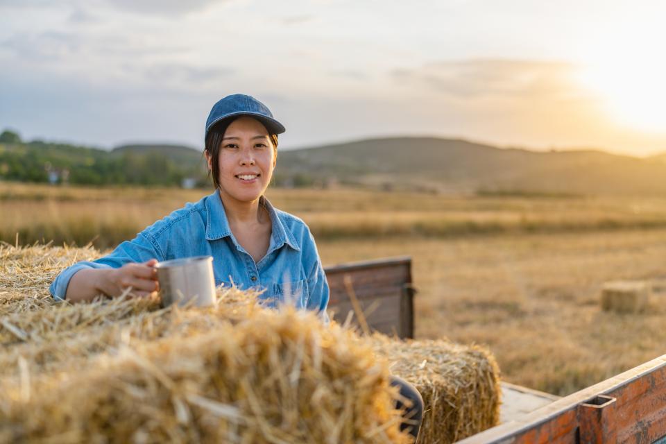 women dressed in blue in front of some hay